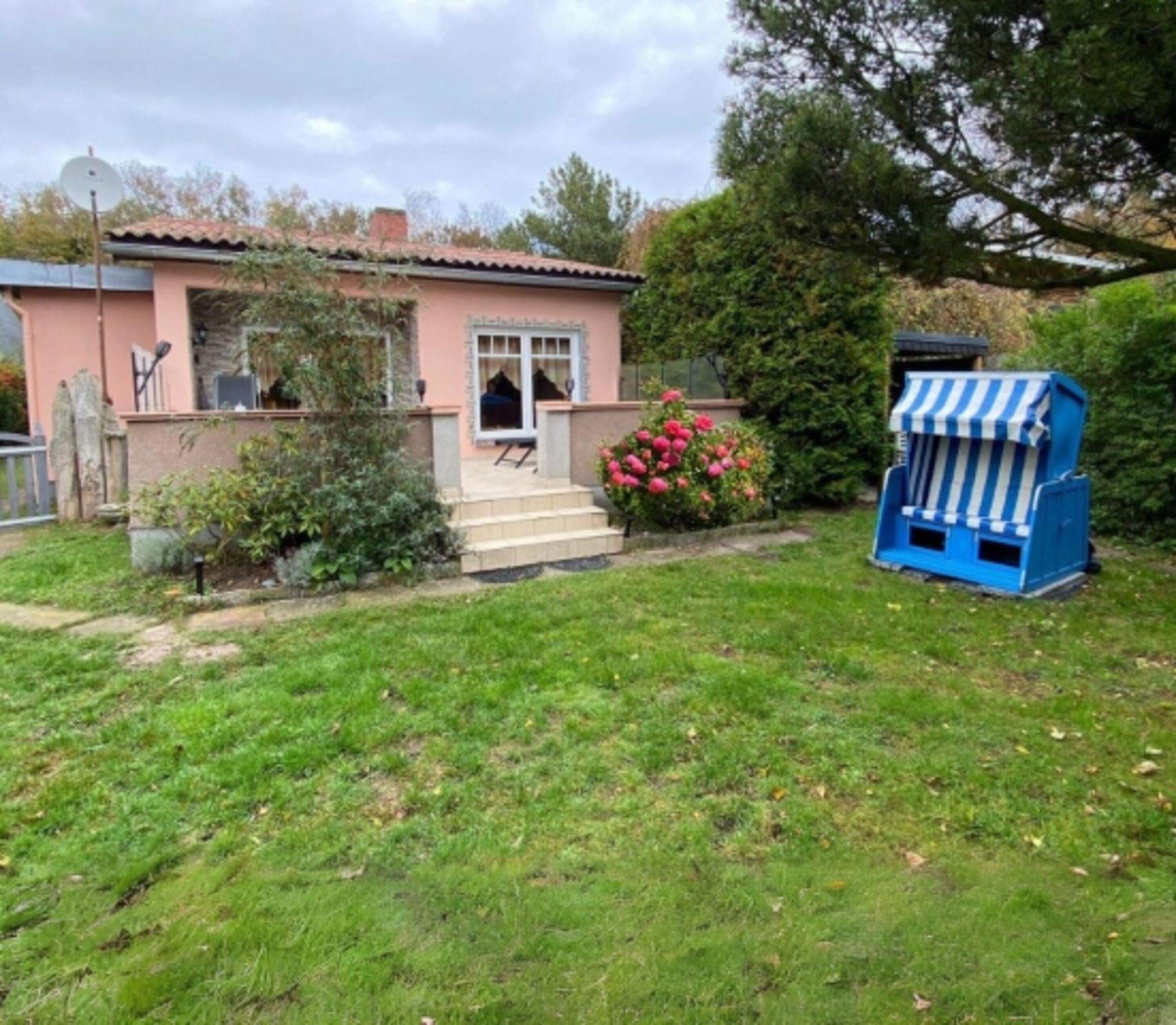 eingezäunter Gartenteil mit Strandkorb