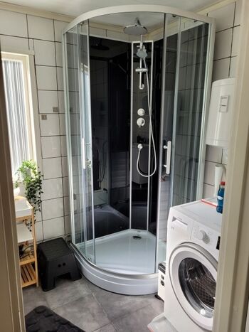 Dusche und Waschmaschine im Bad