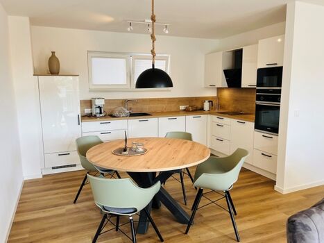 Essbereich mit moderner, voll ausgestatteter Einbauküche