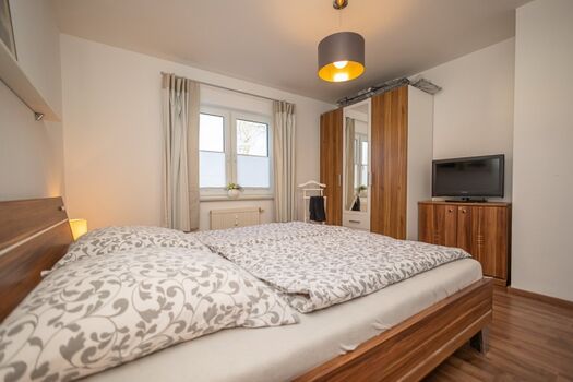 Schlafzimmer mit gräumigem Schrank und TV