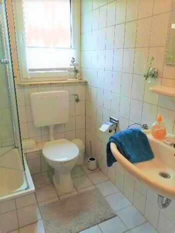 weiß gefliestes Bad mit Fenster...