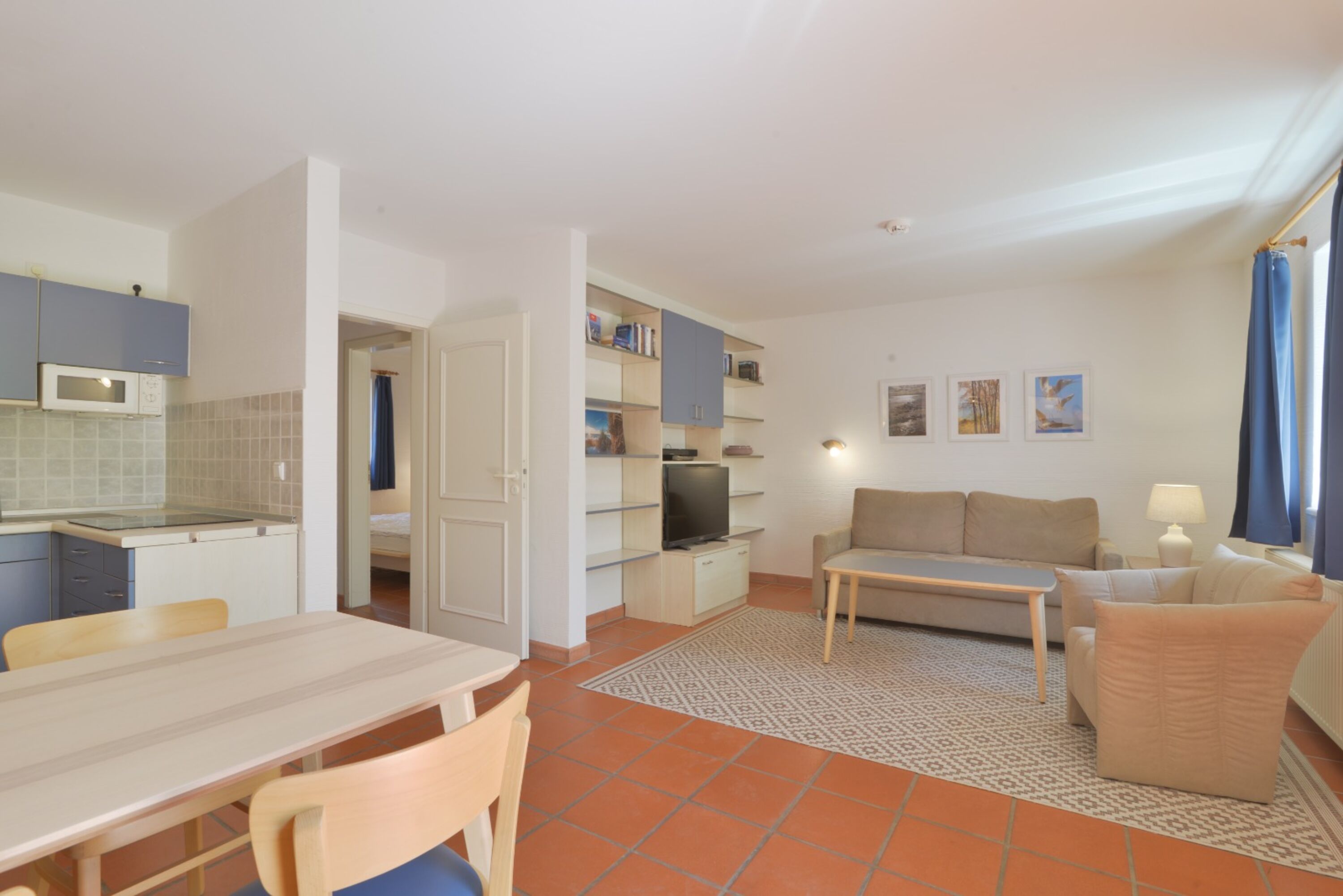 Blick durch den Wohnraum mit Essplatz, im Hintergrund die Küche und das Schlafzimmer