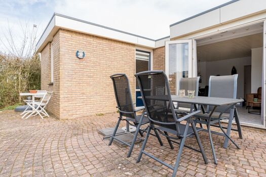 Die sonnige Terrasse mit Gartenmöbeln