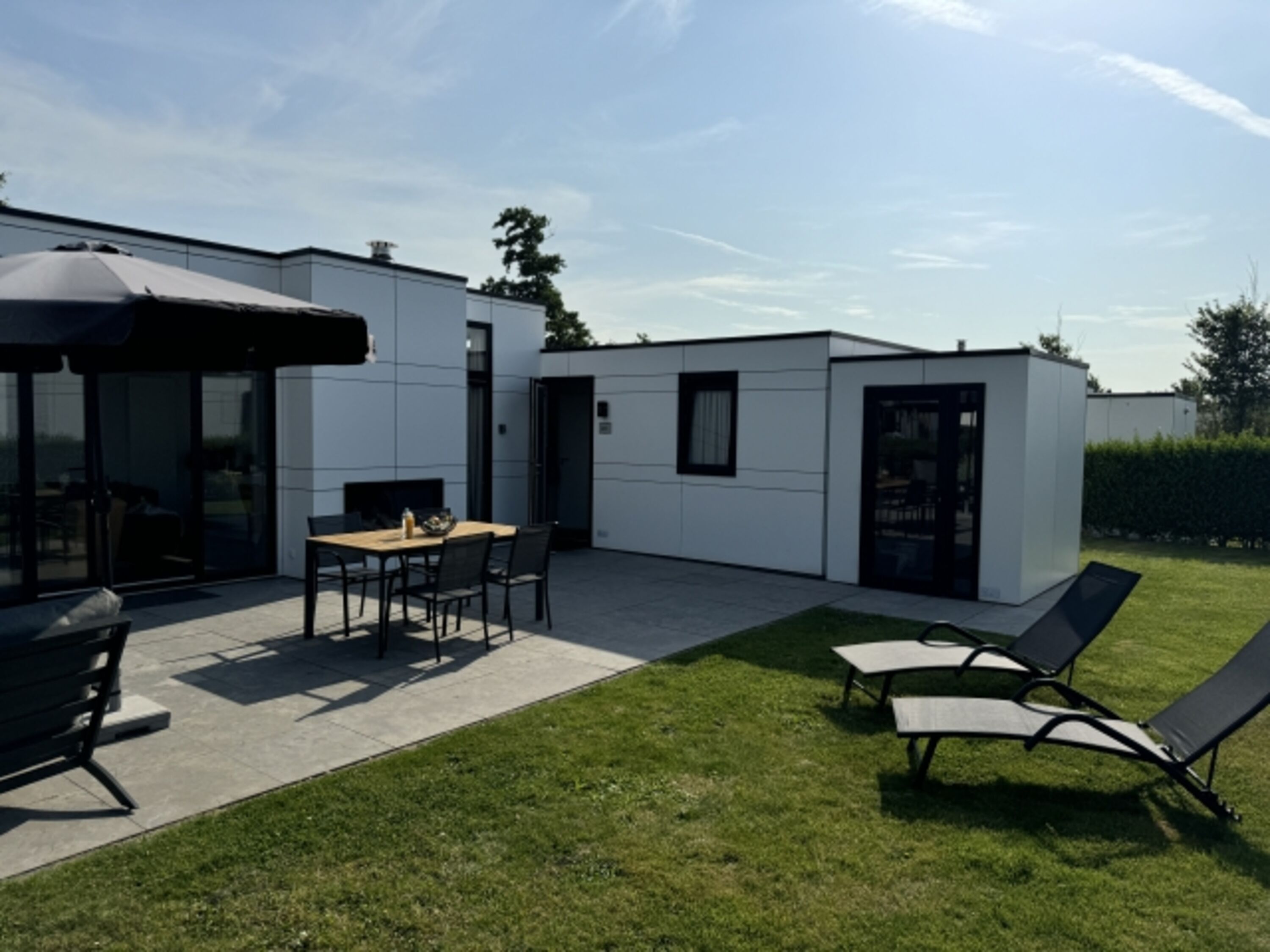 mit Lounge, Liegestühlen und Sonnenschirm