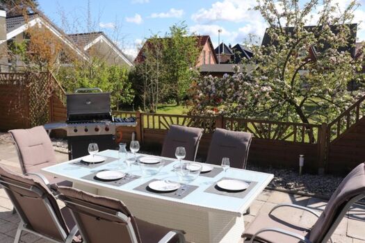 Südterrasse mit großem Esstisch und Sonnenliegen