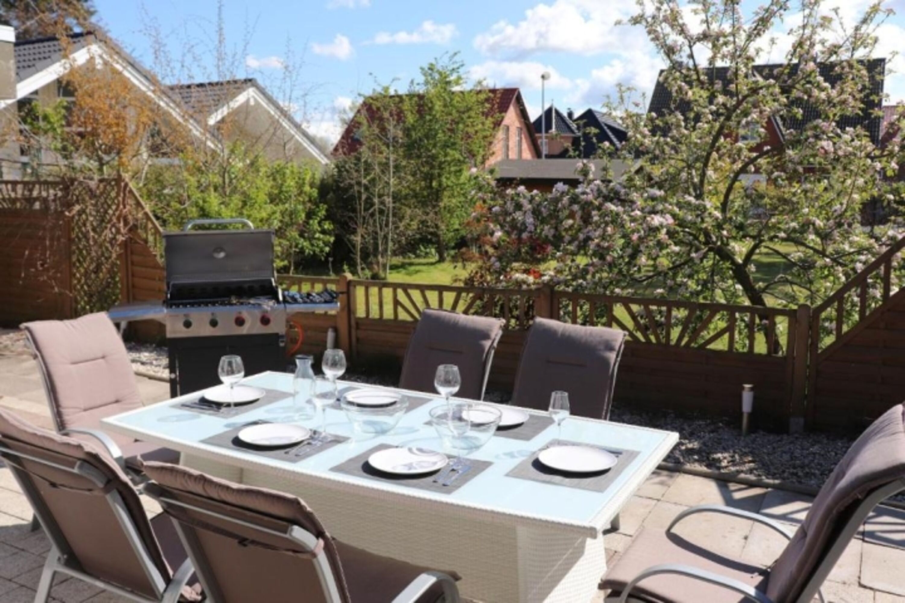 Südterrasse mit großem Esstisch und Sonnenliegen