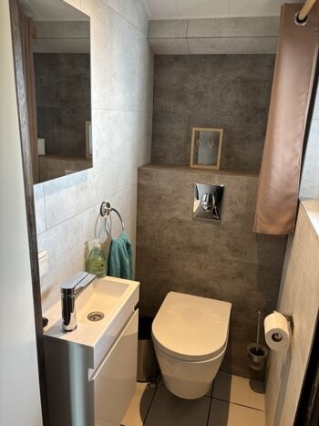 Gästebad mit Toilette und Waschbecken