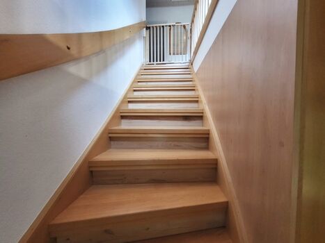 geschlossene Holztreppe mit Treppenschutzgittertür