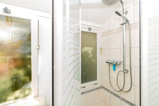 Badezimmer 1 mit Dusche, Waschbecken und Toilette