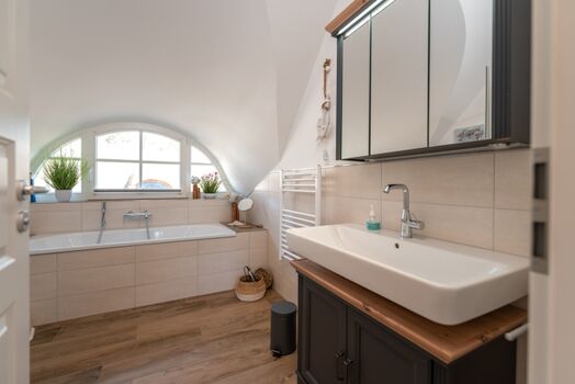 Badezimmer mit Badewanne und Dusche im Obergeschoss