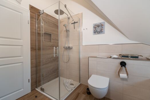 Badezimmer mit Badewanne und Dusche im Obergeschoss