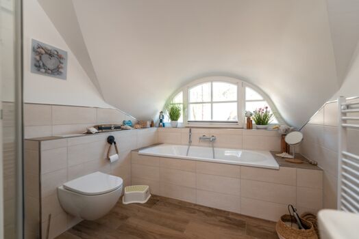 Badezimmer mit Badewanne und Dusche im Obergeschoss