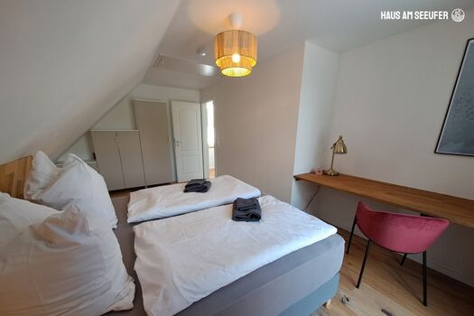 Schlafzimmer 1 mit Boxspringbett und Arbeitsplatz