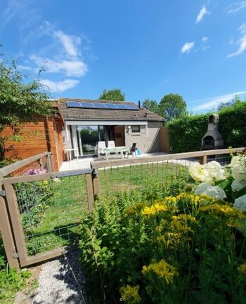 Sonnengarten mit Zaun und Steingrill 