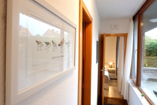 Schmaler Flur mit großen Fenstern zur Terrasse