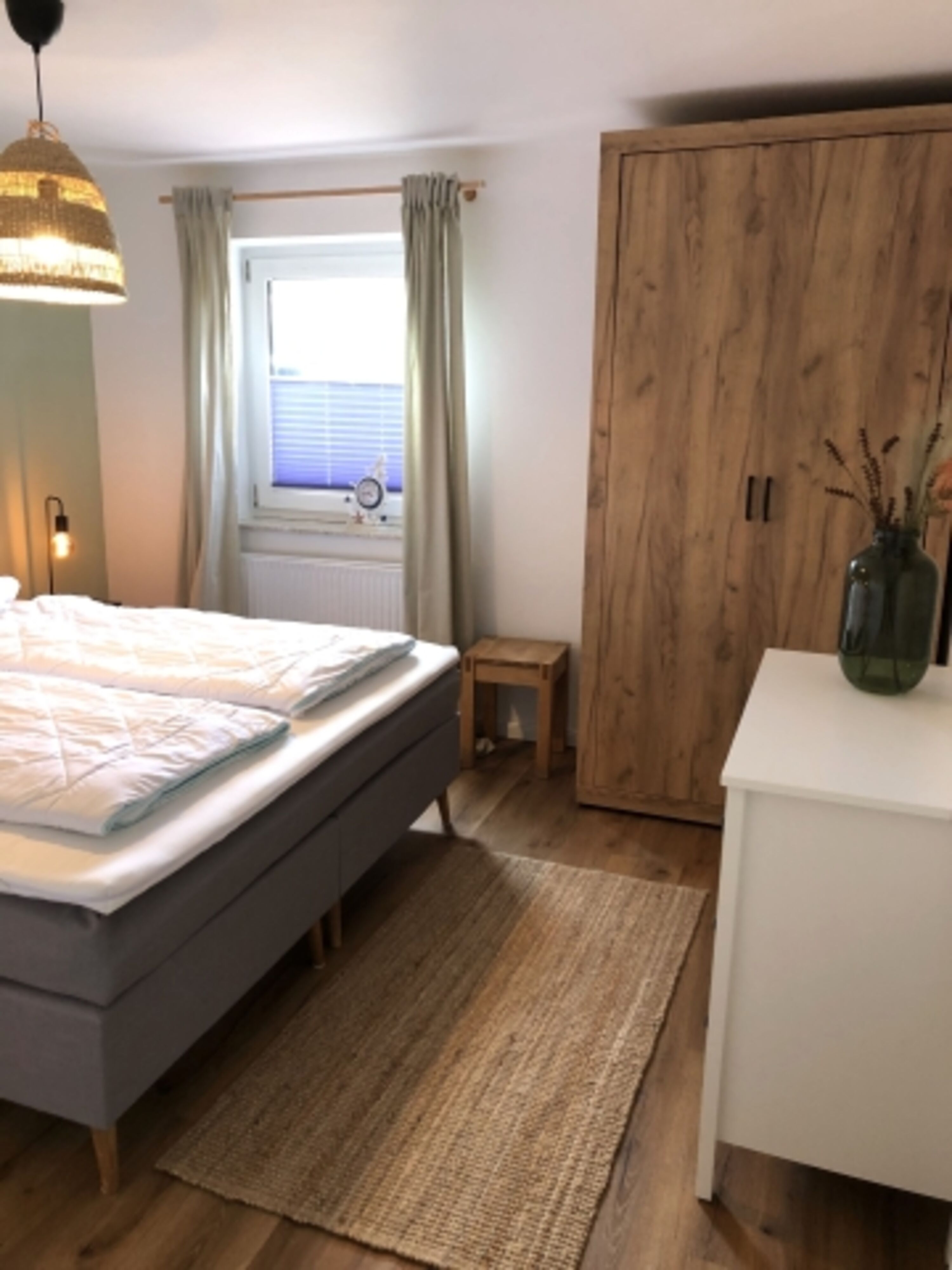 Schlafzimmer mit Boxspringbett, Kleiderschrank mit Bügeln und Kommode