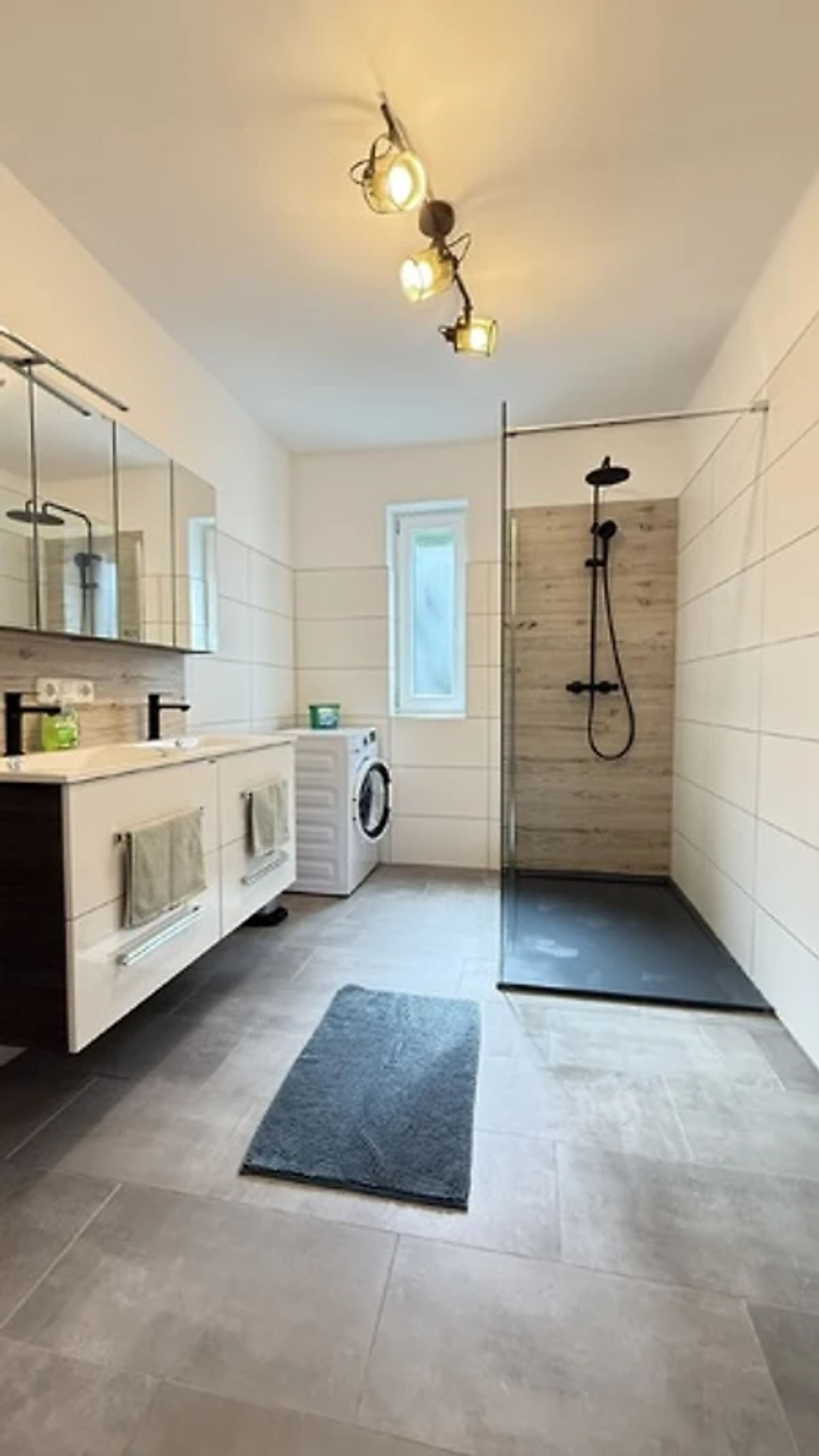 Badezimmer 1 mit Doppelwaschbecken, Waschmaschine und Dusche. Toilette extra.