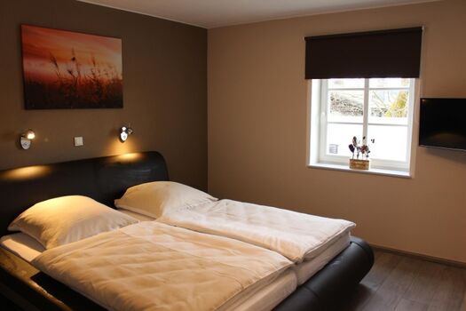 Schlafzimmer 1 - Doppelbett - Waschbecken - TV