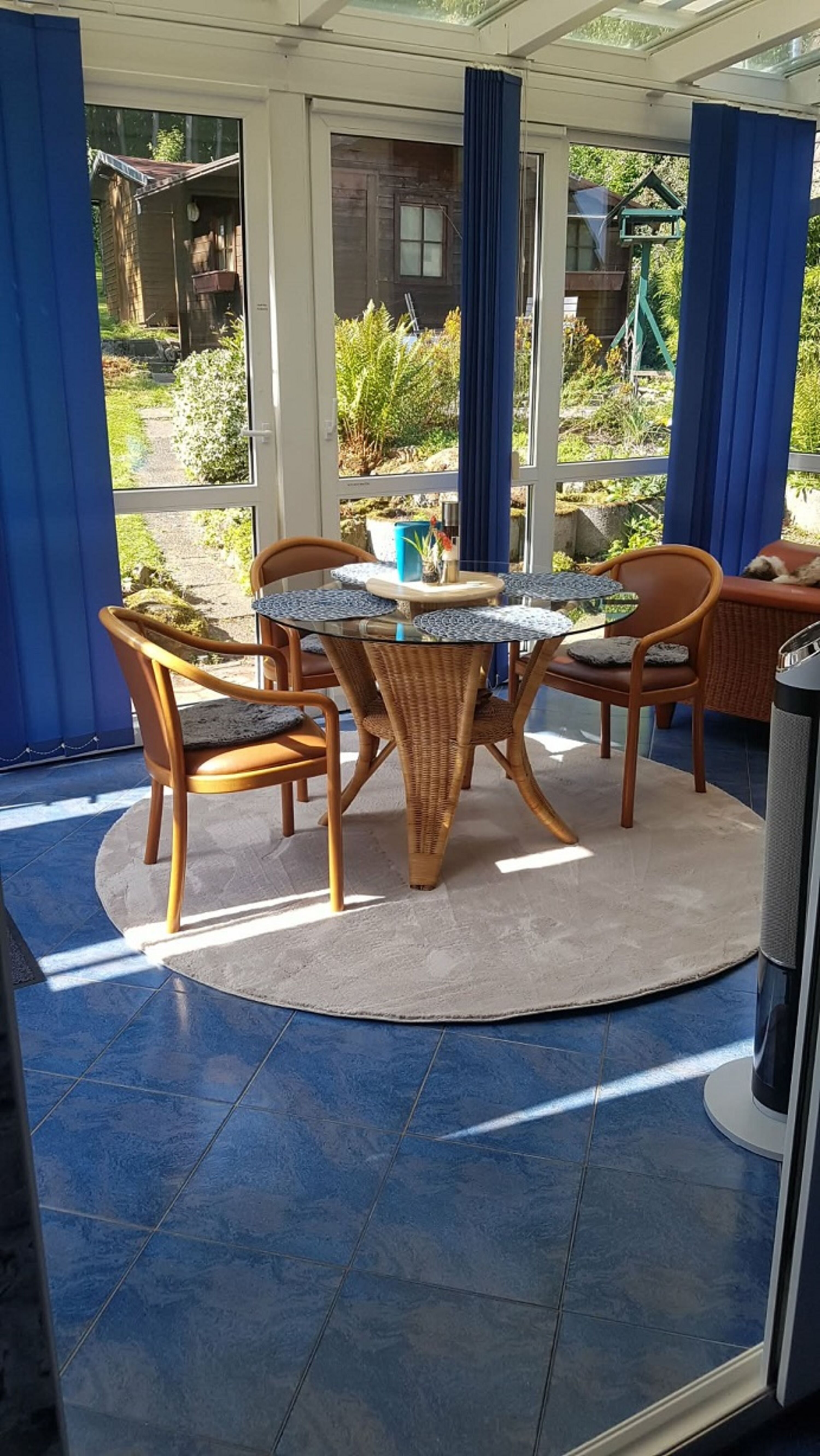 Wintergarten mit Esstisch und Relaxsessel