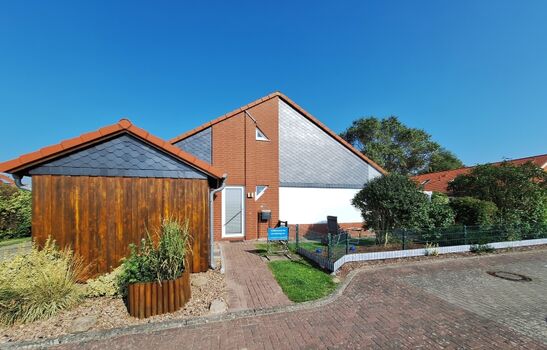 Hausansicht mit Stellplatz und Schuppen