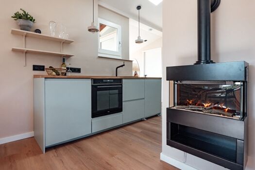 Mamooi - Blick in die Küche mit Kaminofen