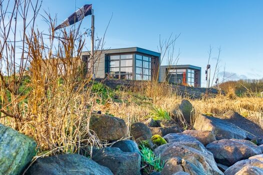 Sicht vom IJsselmeer auf das Chalet Strandjuwel vorn am Ufer