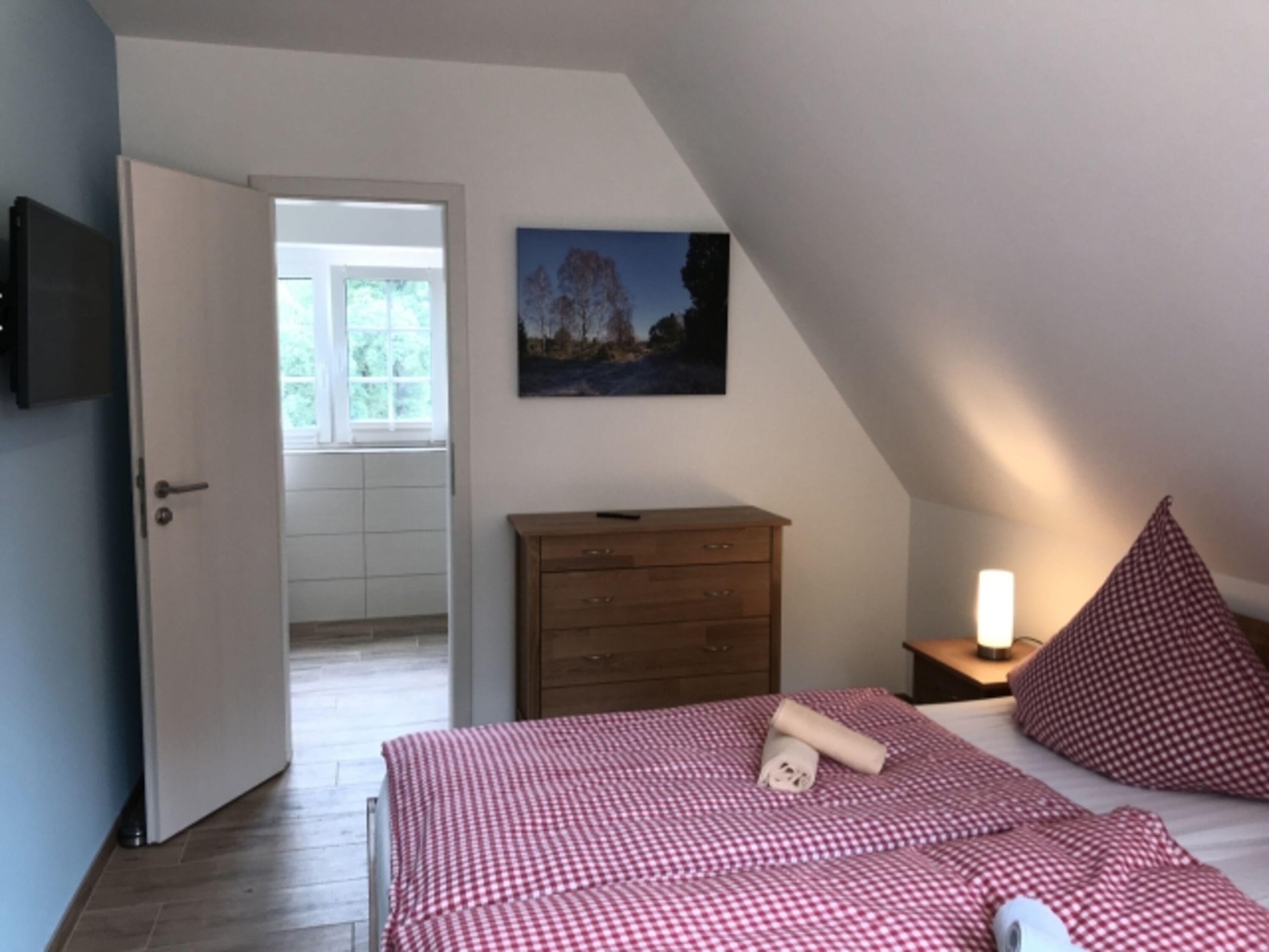 Schlafzimmer mit Doppelbett und Smart-TV