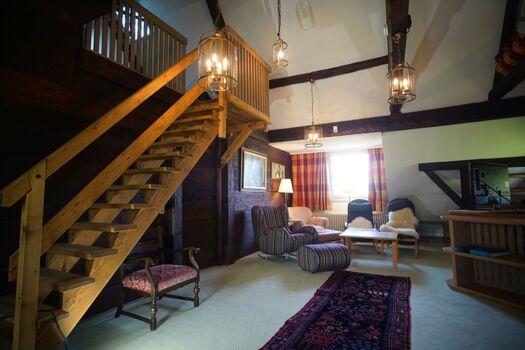 Lounge in der Tenne mit Aufgang zum Dachspitz