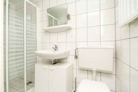 Badezimmer mit Dusche, Waschbecken und Toilette