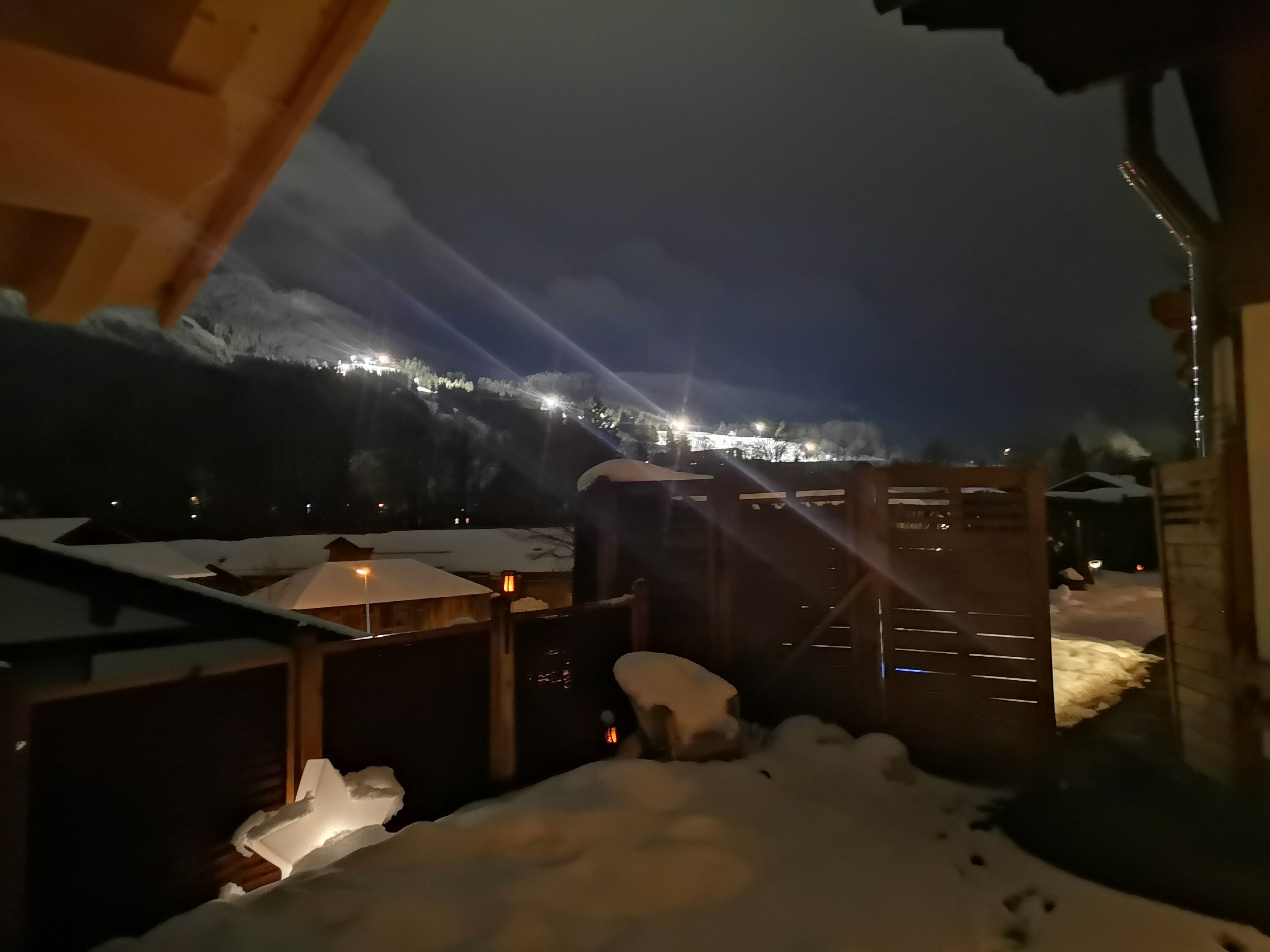 Blick aus der Sauna auf die beleuchtete Skipiste