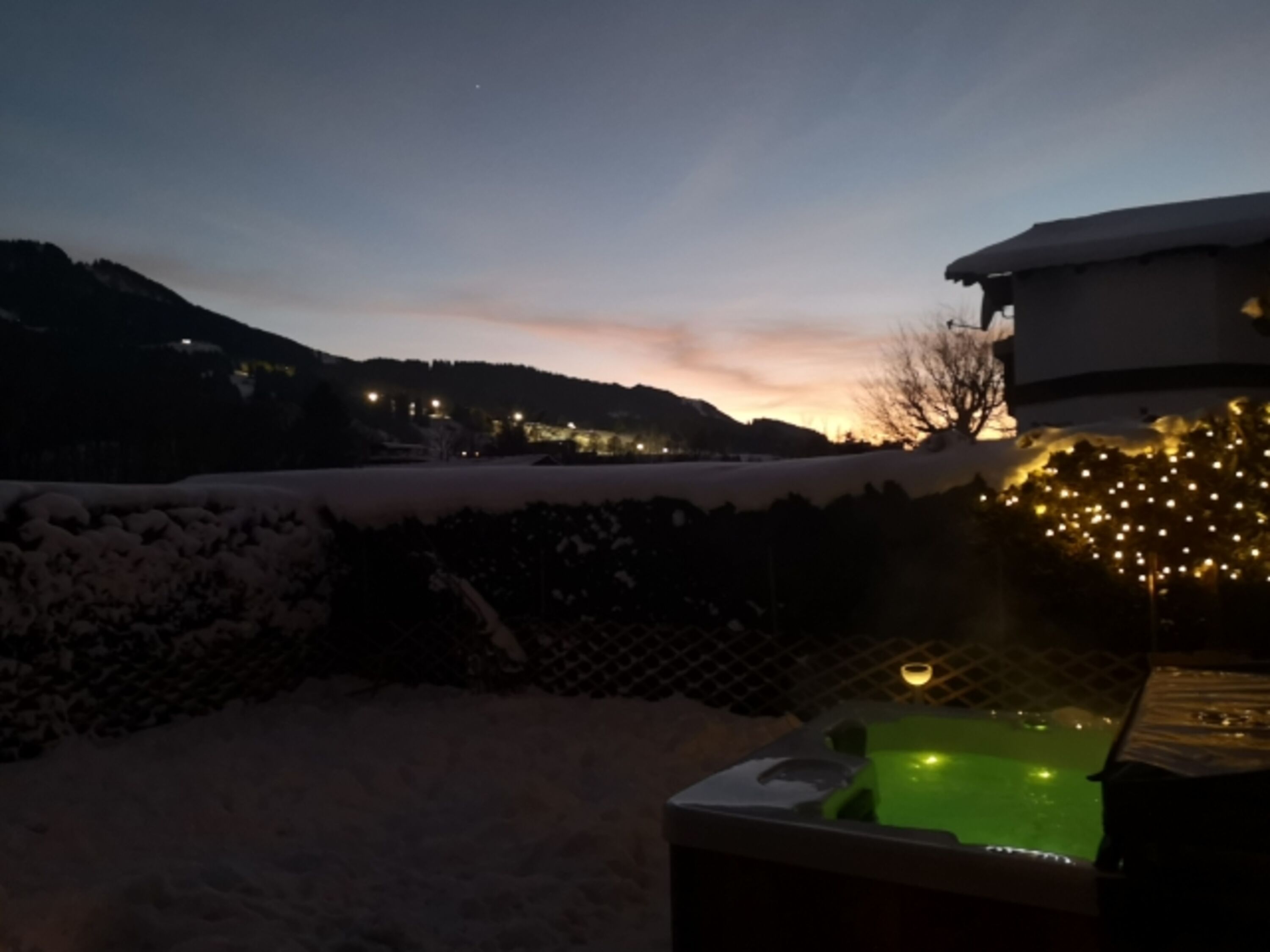 Whirlpool mit Blick auf die beleuchtete Skipiste