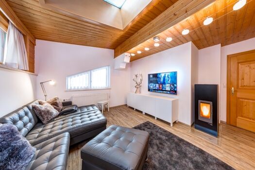 Wohnzimmer mit Pelletofen (vollautomatisch), Echtledercouch mit Federkern 65 Zoll 4k Sat TV mit Netflix