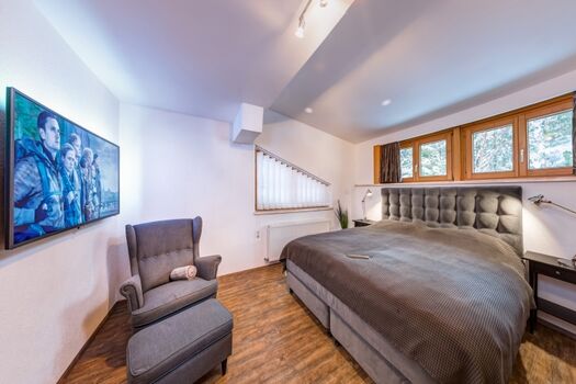 King Size Boxspring Bett (200×180) 55 Zoll 4k Sat TV mit Netflix, Ohrensessel mit kleinem Hocker