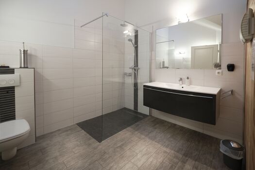 Wellnessbad mit bodengleicher Dusche und Raindance Shower, privater Sauna und Fußbodenheizung