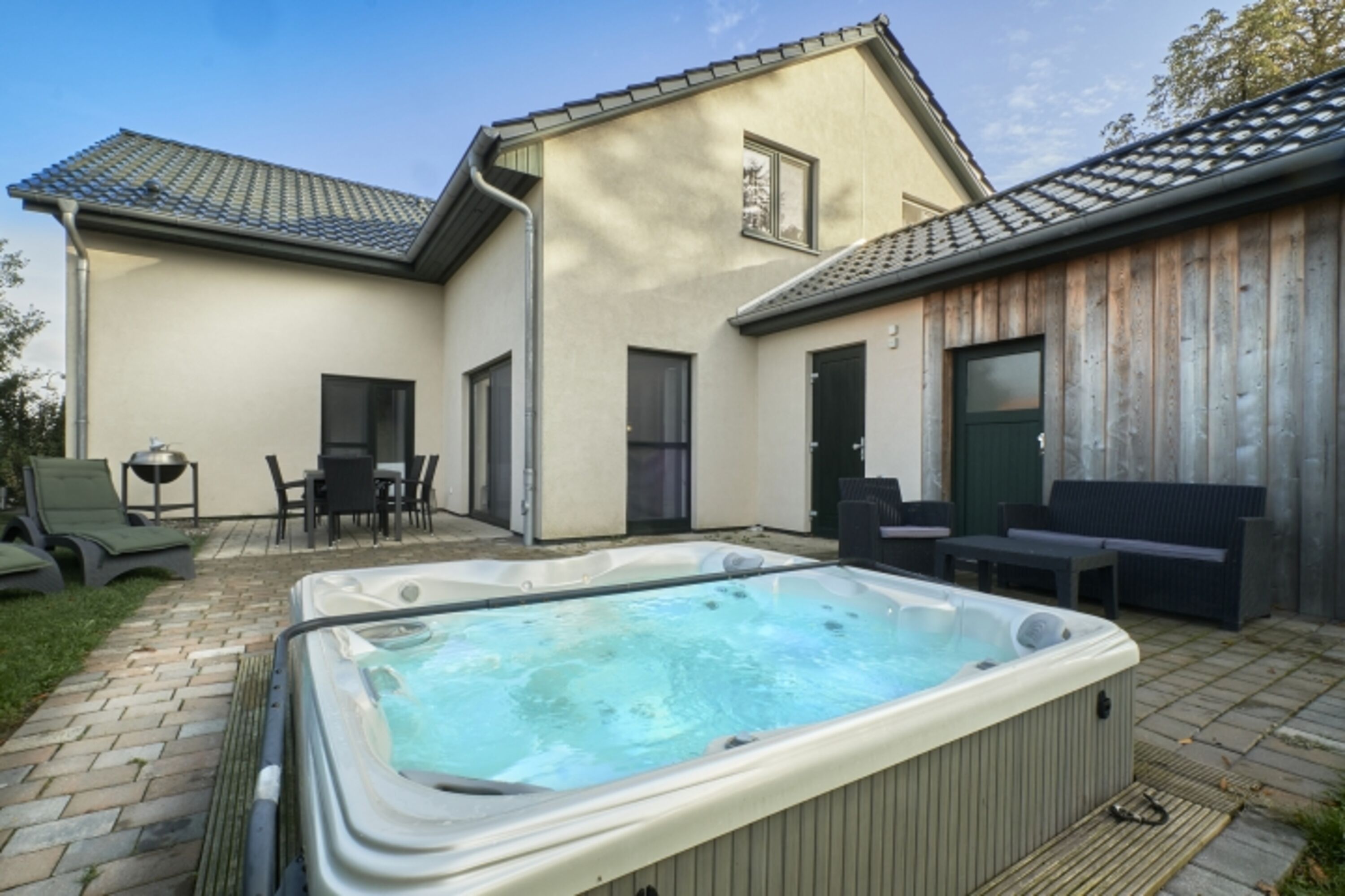 Blick zur Terrasse mit Holzkohlegrill und Ess Sitzgruppe