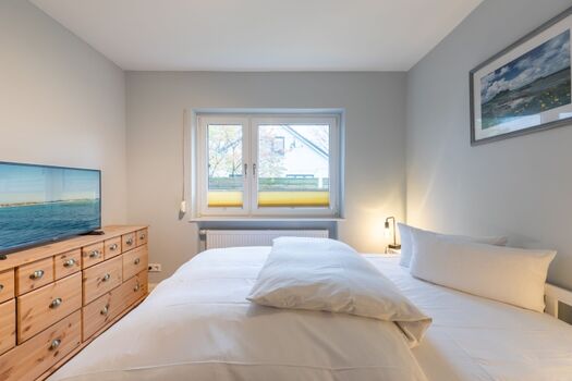 Ferienhaus Deichglück - Schlafzimmer mit großem Doppelbett und TV im Erdgeschoss 