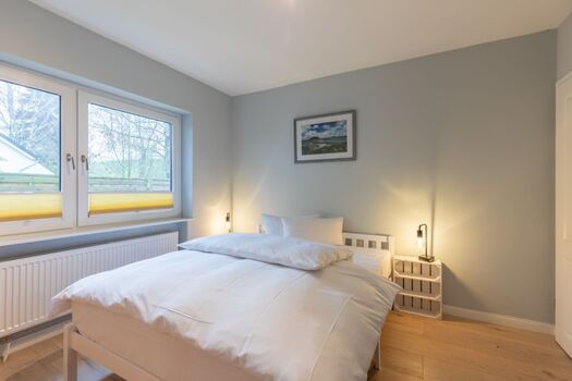 Ferienhaus Deichglück - Schlafzimmer mit großem Doppelbett im Erdgeschoss 