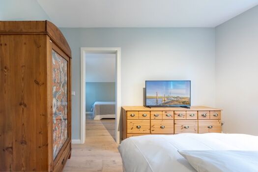 Ferienhaus Deichglück - Schlafzimmer mit großem Doppelbett und TV im Erdgeschoss 