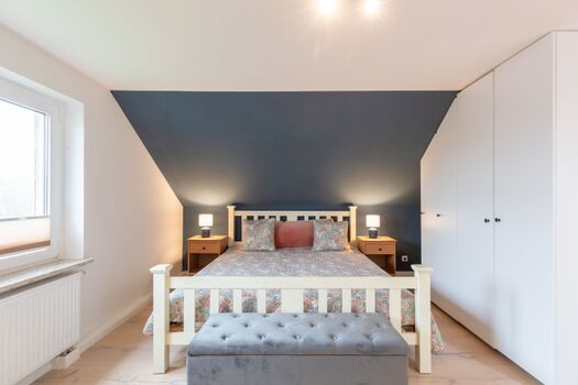 Ferienhaus Deichglück - Schlafzimmer mit großem Doppelbett im OG