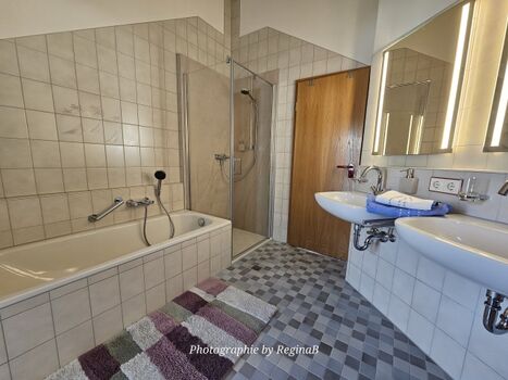 Badezimmer mit bodenebener Dusche/Wanne und WC