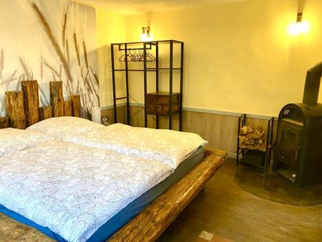 Schlafzimmer mit Kaminofen und Fernseher