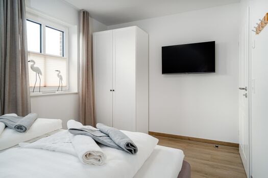 Schlafzimmer mit ausreichend Stauraum und TV