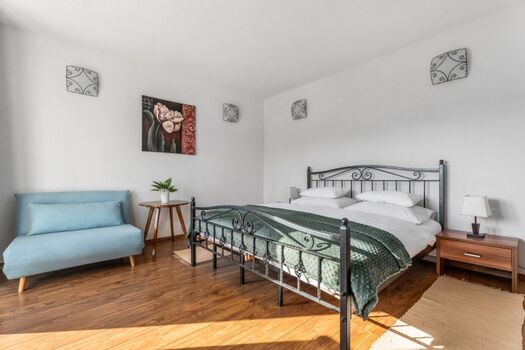 Ein Schlafzimmer Nr. 2 mit einem Kingsize-Bett, einem Sofa, Klimaanlage und einem Balkon mit Blick auf den Pool