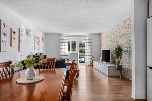 Esstisch, Wohnzimmer mit sehr bequemem Sofa, einem Fernseher und einem Balkon mit Blick auf den Pool