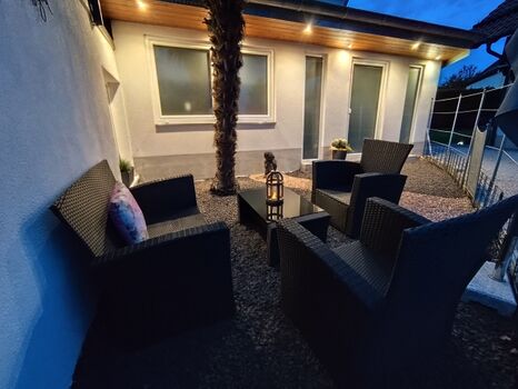 Terrasse mit Lounge Möbeln unter einer Palme