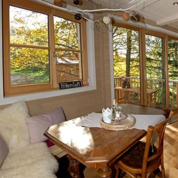 Die Wohnküche unseres Baumhauses mit Panoramafenster in die Natur