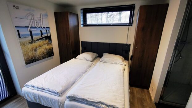 Hauptschlafzimmer mit TV und angrenzendem eigenen Bad.