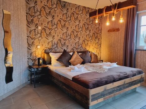 Schlafzimmer mit Doppelbett und TV