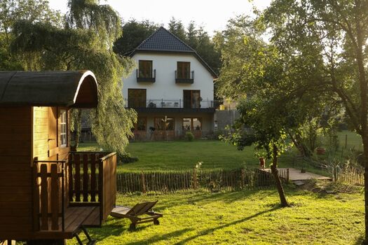 Hausansicht vom Garten aus. Ferienwohnungen liegen im Dachgeschoss.