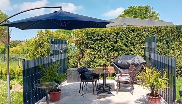 Windgeschützte Terrasse mit Sonnenschirm 